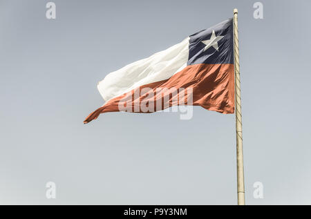 Bandiera del Cile vola in un vento forte contro un luminoso cielo blu con i riflessi del sole. Simbolo patriottico del Cile, America del Sud. Immagine con vintage e yester Foto Stock