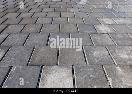 Fotografato vicino con una profondità di campo ridotta e in corrispondenza di un angolo di lastra di pavimentazione di una strada pedonale Foto Stock