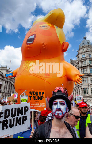 Anti Trump manifestanti portano un 'arrabbiato " Baby Blimp gonfiabile beffando il presidente attraverso le strade del centro di Londra, Londra, Inghilterra Foto Stock