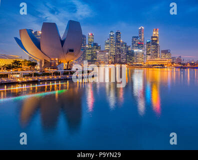 Lo skyline di Singapore e ArtScience Museum al crepuscolo. Foto Stock