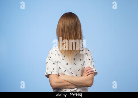 Una donna europea il viso coperto con i suoi capelli, cercando di nascondere a causa della vergogna Foto Stock
