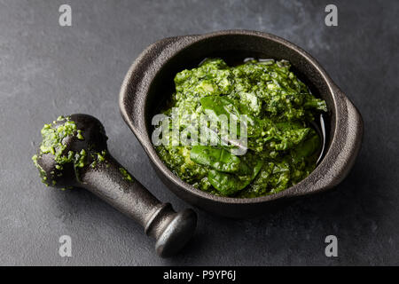 Pesto di basilico salsa in mortaio di ferro, vista ravvicinata Foto Stock