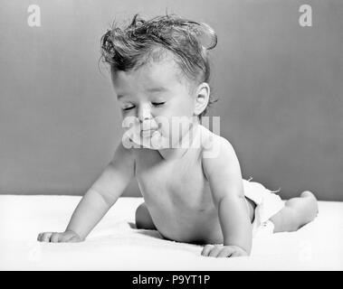 Negli anni quaranta anni cinquanta il bambino giacente su stomaco appoggiata sulle mani GLI OCCHI CHIUSI - b3635 HAR001 HARS SU STOMACO SOUR BAMBINA IN BIANCO E NERO di etnia caucasica HAR001 in vecchio stile in aumento Foto Stock