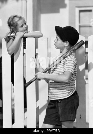 Negli anni quaranta anni cinquanta BOY mazza da baseball CAP parlando a ragazza SU BIANCO Picket Fence - bx012617 CAM001 HARS FEMMINE FRATELLI VERTICALE HOME VITA spazio copia persone bambini amicizia a metà lunghezza ragazzo adolescente di sesso maschile fratelli sorelle B&W VICINI RAGAZZA PRETEEN BOY sogni di felicità quartiere CAM001 PRETEEN GEMELLI FIDANZATI FIDANZATE CRUSH cucciolo amore affetto novellame pre-teen pre-teen BOY PRE-TEEN GIRL convivere in bianco e nero di etnia caucasica in vecchio stile Foto Stock