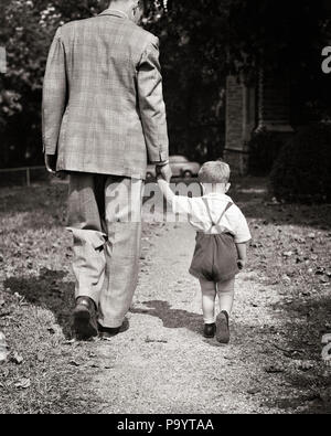 1940s LITTLE BOY TODDLER Holding Hands camminando accanto all uomo padre - J10746 HAR001 HARS FAMIGLIE GIOIA CASA RURALE VITA spazio copia amicizia a tutta lunghezza persone cura maschi padri B&W papà in direzione tenendo le mani vista posteriore del giovane e la vecchia generazione collegamento accanto a vista posteriore la crescita novellame MID-adulto metà uomo adulto AFFIANCATI STARE INSIEME GRANDI E PICCOLI IN BIANCO E NERO di etnia caucasica HAR001 in vecchio stile Foto Stock