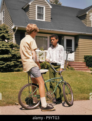 Anni sessanta anni settanta African American Boy parlando a CAUCASIAN Ragazzo seduto sulla bici sul marciapiede suburbana - KB7275 HAR001 HARS il trasporto bici vicini PRETEEN BOY quartiere afro-americani afro-americano etnia nero connessione opportunità di crescita ed elegante il novellame di pre-teen pre-teen BOY affiatamento etnia caucasica HAR001 in vecchio stile afro-americani Foto Stock