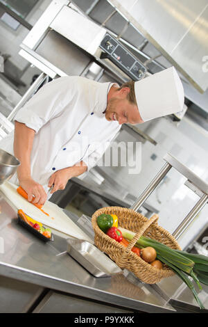 Bello chef preparare insalata in ristorante cucina Foto Stock