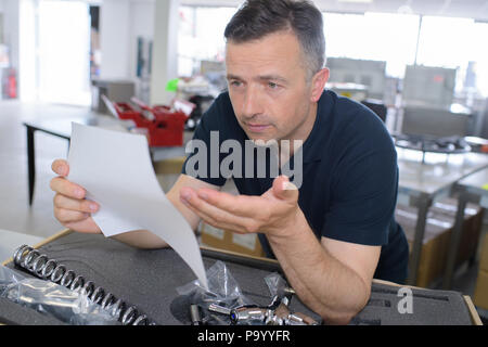 Giovane uomo un controllo manuale prima installazione Foto Stock