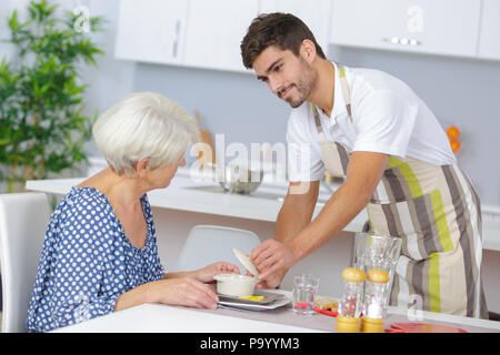 Accompagnatore che serve un senior lady Foto Stock