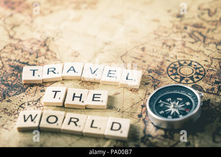 Viaggiare per il mondo del testo in legno con vintage map compass Foto Stock