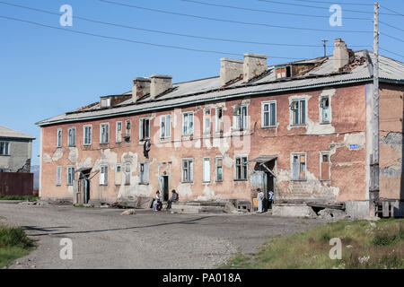 La gente del posto nella parte anteriore di una corsa verso il basso del blocco alloggiamento in Lorino, Chukotka, Russia Foto Stock