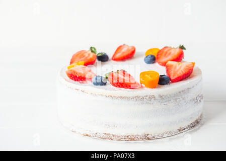 Deliziosa crema yougurt sani torta con fragole fresche, mirtilli sullo sfondo bianco. Immagine di un menu o di un catalogo di prodotti dolciari. Sel Foto Stock