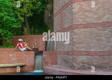 Ciclista in appoggio a Sesquicentennial vicino a Buffalo Bayou presso il Wortham Center in downtown Houston. Foto Stock