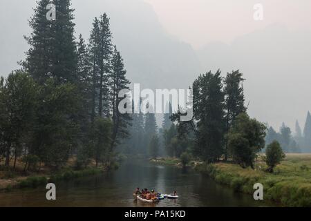 Parco Nazionale di Yosemite in California, Stati Uniti d'America. 19 Luglio, 2018. Parco Nazionale di Yosemite visitatori galleggiante nel fiume Merced vicino Ponte oscillante sotto pesante fumo e foschia creata dal fuoco Ferguson giovedì 19 luglio, 2018. Sotto un cielo terso, Yosemite Falls potrebbe facilmente essere visto dietro il parco i visitatori. Il fuoco ha cominciato il 13 luglio e ha bruciato oltre 21.000 acri vicino al parco. Due i vigili del fuoco hanno subito delle lesioni e un vigile del fuoco ha perso la vita. Credito: Tracy Barbutes/ZUMA filo/Alamy Live News Foto Stock