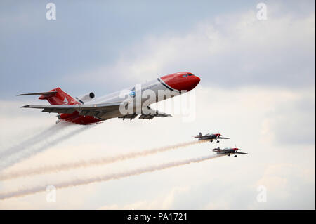 Farnborough, Hampshire, Regno Unito. 19 Luglio, 2018. Due membri delle lame Aerobatic Team Display trail fumo come essi accompagnano il Boeing 727 di fuoriuscite di olio in risposta ad un display sul giorno quattro del Farnborough Airshow Internazionale (FIA) che si sta svolgendo a Farnborough, Hampshire, Regno Unito. L'air show, una vetrina biennale per il settore dell'aviazione, è il più grande del suo genere e attira civile e militare di acquirenti provenienti da tutto il mondo. visitatori professionali sono normalmente in eccesso di centomila persone. Credito: Michael Preston/Alamy Live News Foto Stock