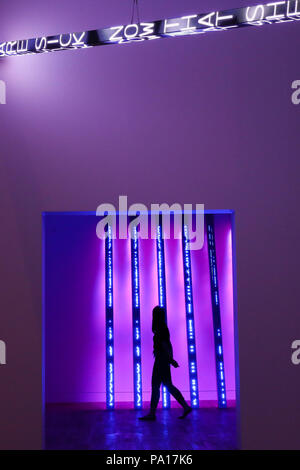 Tate Modern. Londra. Regno Unito 20 luglio 2018 - Un membro del personale passeggiate oltre il blu porpora inclinazione, un LED scultura di testo. Jenny HolzerÕs il lavoro è il più recente di una serie di annuale libero visualizza nell'Artista Camere presso la Tate Modern che si apre al pubblico lunedì 23 luglio 2018. Jenny Holzer (b.1950) è rinomata per il grassetto e basata su testo di installazioni che incorporano la diversità dei mezzi di informazione e un pionieristico uso di tecnologie elettroniche. Credito: Dinendra Haria/Alamy Live News Foto Stock