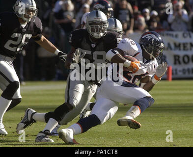 Oakland, la California, Stati Uniti d'America. 22 dic 2002. Denver Broncos running back Clinton Portis (26) corre lontano da Oakland Raiders linebacker Napoleon Harris (58) Domenica, 22 dicembre 2002, a Oakland, in California. I raider hanno sconfitto i Broncos 28-16. Credito: Al di Golub/ZUMA filo/Alamy Live News Foto Stock