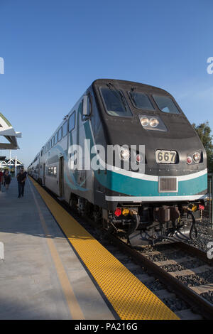 La mattina presto in direzione Sud American Metrolink treni passeggeri in partenza Tustin stazione in Orange County in California USA Foto Stock