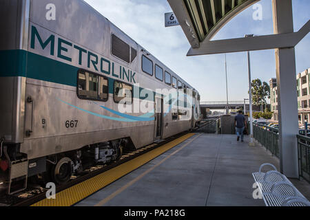 La mattina presto in direzione Sud American Metrolink treni passeggeri in partenza Tustin stazione in Orange County in California USA Foto Stock