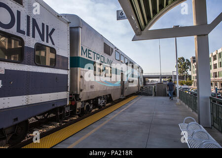La mattina presto in direzione Sud American Metrolink treni passeggeri in partenza Tustin stazione in Orange County in California USA Foto Stock