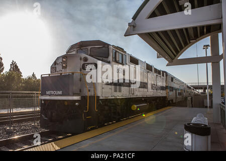 La mattina presto in direzione Sud American Metrolink treni passeggeri in partenza Tustin stazione in Orange County in California USA Foto Stock