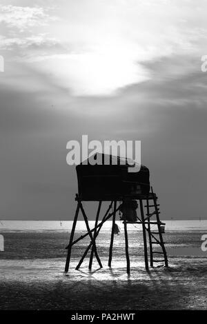 Alba sulla spiaggia con un corpo di guardia come un mezzo per i pescatori di pesce offerta clam per tutti. È bello vedere il sorgere del sole in questo viaggio Foto Stock