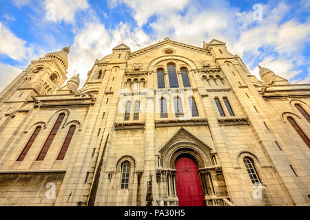 Sul lato sinistro della facciata e la porta della Basilica del Sacro Cuore a Montmartre di Parigi in Francia con il n. di persone. Popolare attrazione religiosa a Parigi città di Francia e d'Europa. Foto Stock