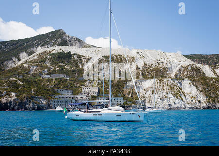Barche ancorate nella parte anteriore delle cave di pomice (cave di pomice) sull'isola di Lipari, Isole Eolie, in Sicilia. Foto Stock