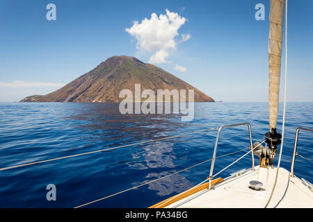 Barca a vela si avvicina l'isola vulcanica di Stromboli e le isole Eolie, in Sicilia. Foto Stock