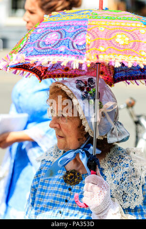 Le donne anziane, 60s, vestito in costume Vittoriano e tenendo colorati ombrellone sun. Broadstairs Dickens week festival. Close up, colpo alla testa. Foto Stock