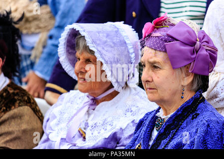 Due le donne anziane, 60s, focus sul primo, seduto a guardare inedito evento. Indossa mauve hat e vestito, costume Vittoriano, parte di Dickens settimana l'evento. Foto Stock