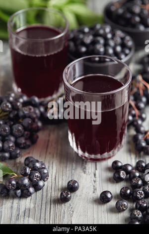 Fresche bacche di Aronia e bacche di Aronia succo in bicchieri Foto Stock