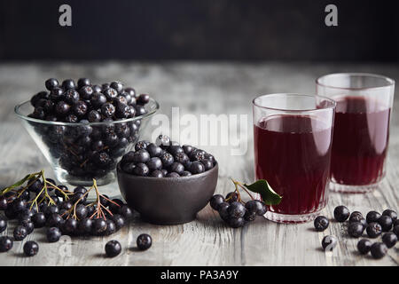 Fresche bacche di Aronia e bacche di Aronia succo in bicchieri Foto Stock