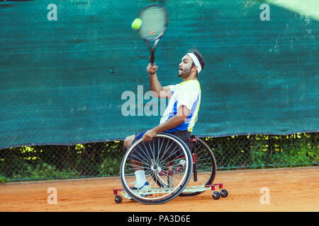 Tennis disabili giocatore colpisce la palla diretti durante una partita all'aperto Foto Stock