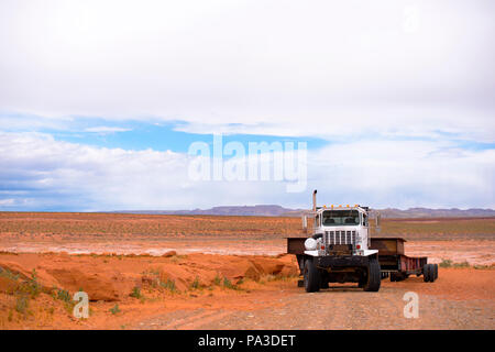 Big Rig extra potente semi trattore con lunghi heavy-duty semi rimorchio per fuorimisura stand in Arizona deserto vicino al lago Powell resort in attesa Foto Stock