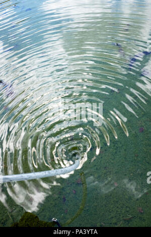 L'origine di waterwaves. L'aria è soffiata sull'acqua, e questo crea un foro nella superficie. Questo foro genera onde d'acqua. Foto Stock