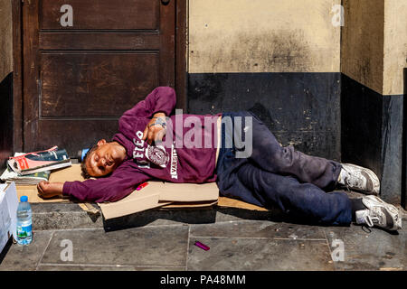 Un uomo addormentato in un portale, Londra, Inghilterra Foto Stock
