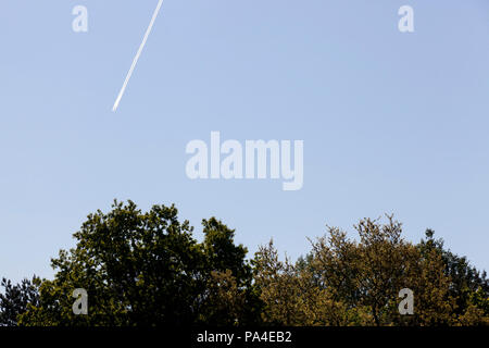 Un sentiero di inversione a partire da un piano di volo contro un cielo blu, bel tempo chiaro, la tecnica a sinistra nuvole artificiali Foto Stock