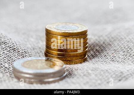 Due e cinque Polish zlotys giacente su un tovagliolo realizzato da lino, close-up di tappeto erboso europea e finanza, concentrarsi sulle monete d oro Foto Stock