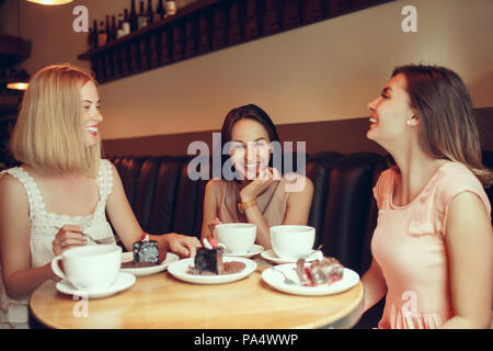 Due amiche trascorrono del tempo insieme a bere caffè nella caffetteria, avendo prima colazione e dessert. Foto Stock