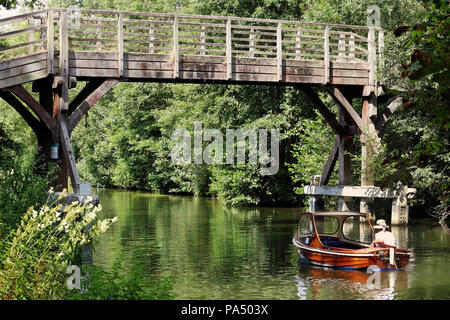 Passerella in legno sul fiume Tamigi a Hurley con la signora in un motore avviare andando al di sotto Foto Stock