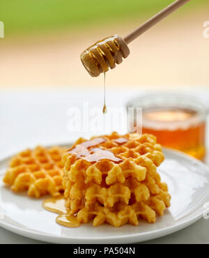 Il miele in un vasetto con la cucchiaia in legno Foto Stock