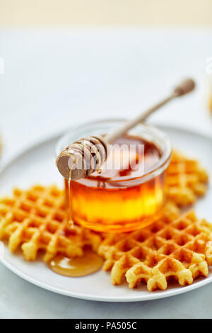 Il miele in un vasetto con la cucchiaia in legno Foto Stock
