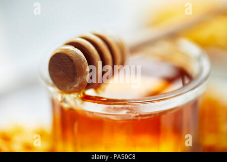 Il miele in un vasetto con la cucchiaia in legno Foto Stock