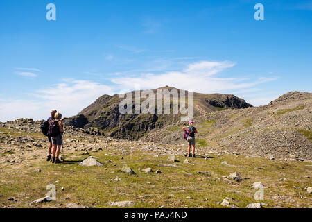 Gli escursionisti sul percorso su Ill Crag e ampia falesia di Scafell Pike vertice di montagne del Parco Nazionale del Distretto dei Laghi, Cumbria, Regno Unito, Gran Bretagna Foto Stock