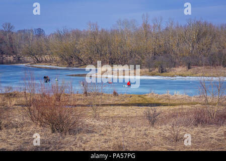 I pescatori su un canale congelate del fiume Narew all'interno di Legionowo County in Masovian voivodato di Polonia Foto Stock