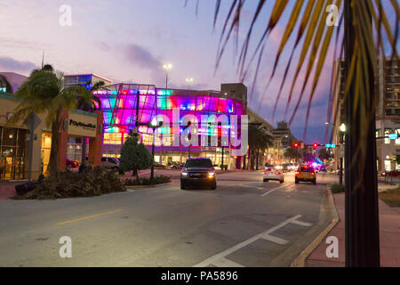 TD Bank, accesa fino all'alba con luci multicolori, Collins Avenue, Miami Beach, SUV ruotando di un angolo con i fari accesi Foto Stock