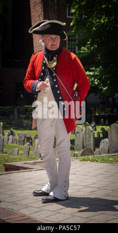 Tour guida vestita in rosso cappotto British guerra rivoluzionaria di lingua uniforme per i turisti presso il granaio Sepoltura sul sentiero della libertà in Boston, MA Foto Stock