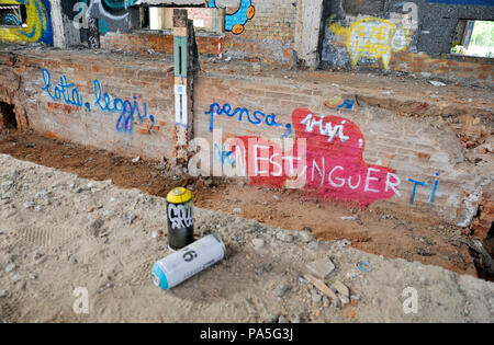 Graffiti utilizzata è in grado di spruzzare in una fabbrica abbandonata. Sullo sfondo dei graffiti. Bologna, Italia. Foto Stock