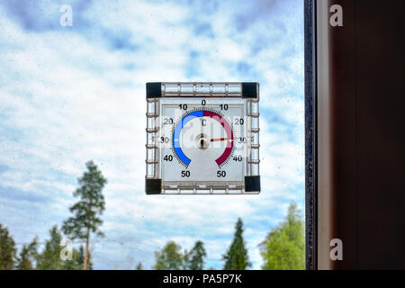 Un termometro sul vetro della finestra che mostra la temperatura calda all'aperto Foto Stock